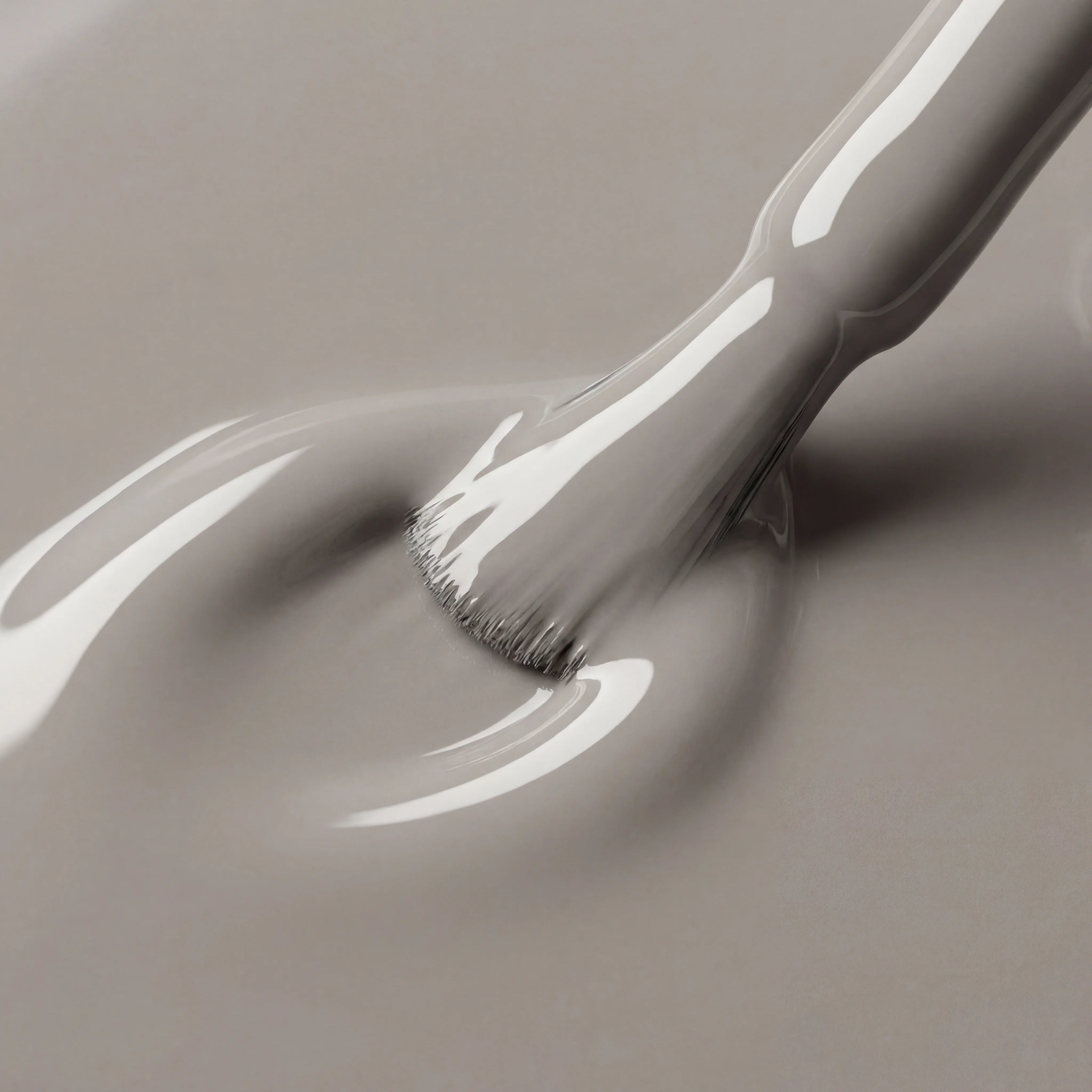 Gray paint being applied with a brush on a gray background